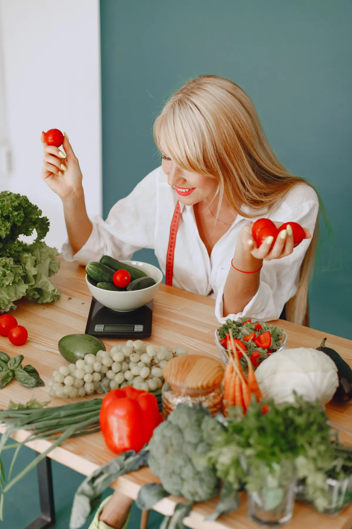 Nutricionista com tomates e legumes frescos na mesa