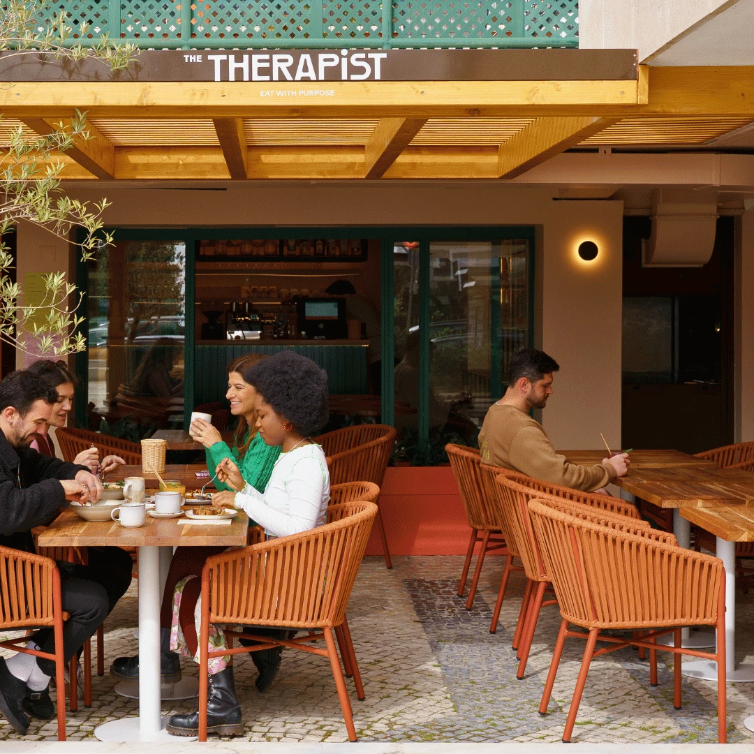 Esplanada do The Therapist com clientes a almoçar em cadeiras de corda cor de laranja